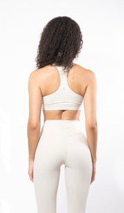girl from behind wearing a sculpting yoga bra in beige