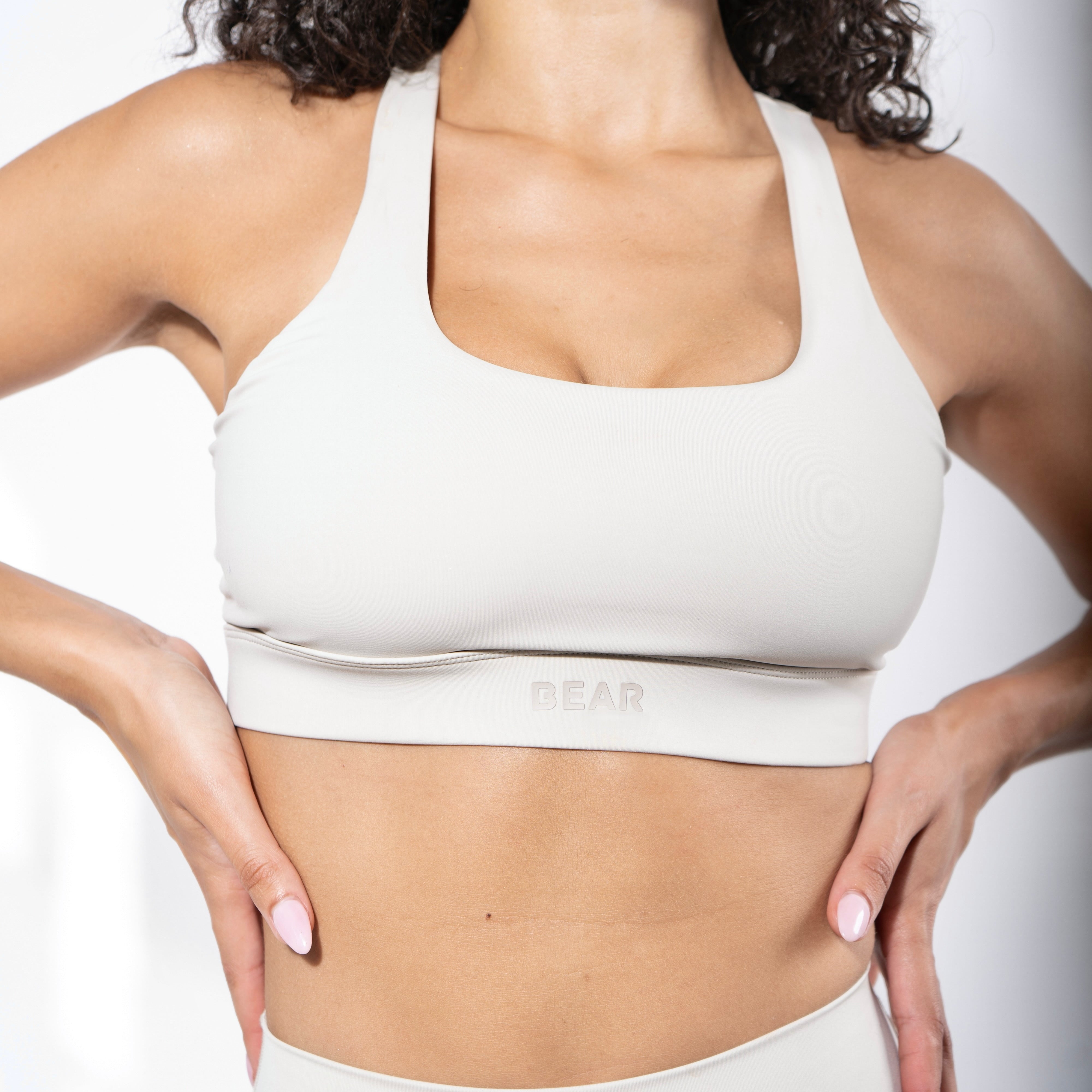 Girl wearing a high Impact Sports Bra in beige